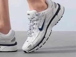 A foot in a white and silver running sneaker