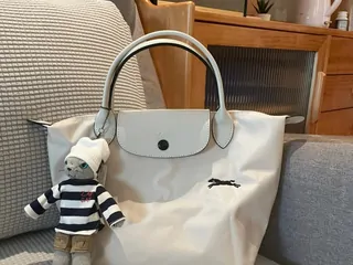 A cream nylon tote bag with leather handles